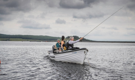 small fishing boat with angler casting a line